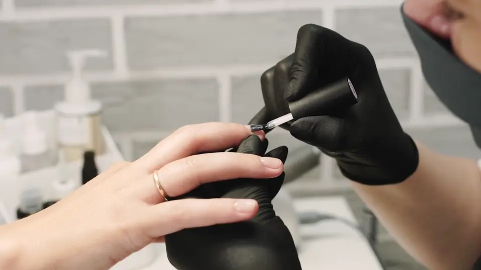 A manicurist painting a client’s nails