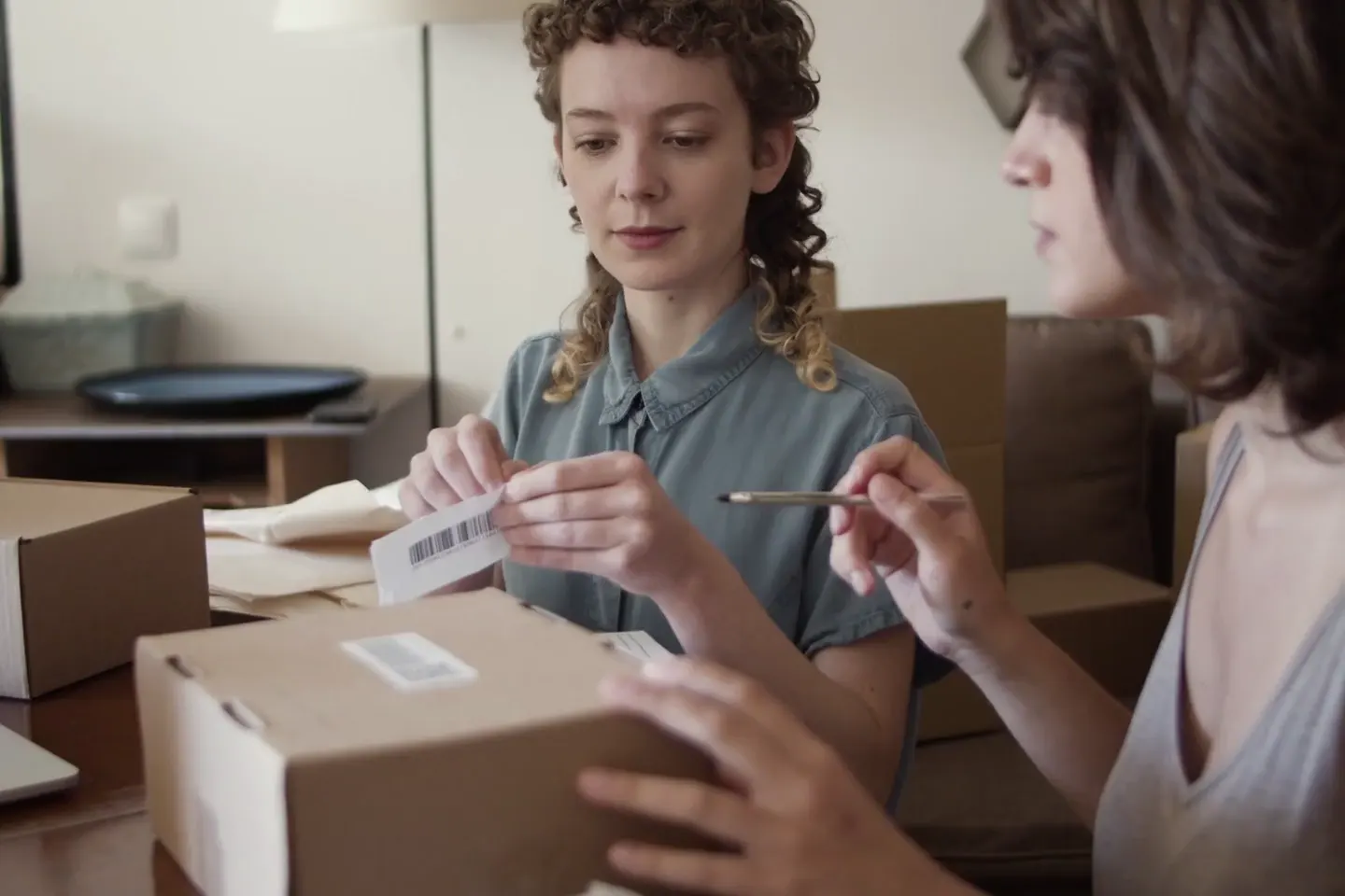 A person packing a parcel with a shipping label